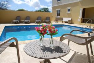 a table with flowers on it next to a pool at Hausmann Penthouse with Stunning Sea View in Kralendijk