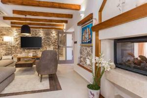 ein Wohnzimmer mit Kamin und Couch in der Unterkunft Luxury Villa Finessa Skradin 1 with heated pool, jacuzzi and sauna in Skradin