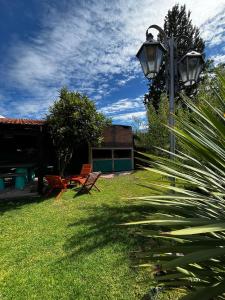 a yard with two chairs and a street light at La Merlina in Merlo +10 photos