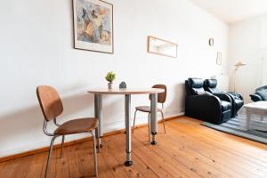 a table and chairs in a living room with a couch at MonteurGut Apartments Birke in Lindern