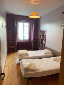 three beds in a room with a window at Gîte des bords de Rance in Langrolay
