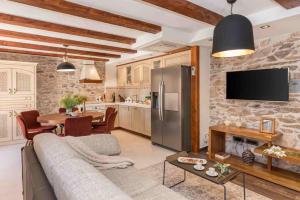 ein Wohnzimmer mit Couch und Küche in der Unterkunft Luxury Villa Finessa Skradin 2 with heated pool, jacuzzi and sauna in Skradin