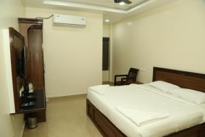a bedroom with a bed and a television in it at Sudha Grand in Chennai