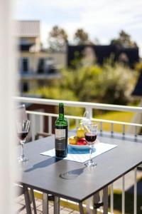 a table with two glasses and a bottle of wine at Moderne Maisonettewohnung In Meernähe in Börgerende-Rethwisch