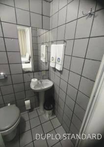 mała łazienka z toaletą i umywalką w obiekcie Titão Plaza Hotel w mieście Campina Grande