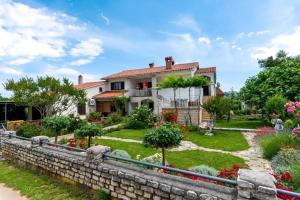una casa con una pared de retención y un jardín en Vinez, en Labin