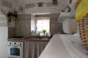 マルティナ・フランカにあるSträflingstrulloのシンクとコンロと窓のあるキッチン