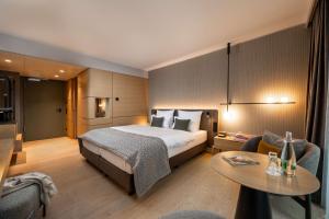 a hotel room with a bed and a table at ATLANTIC Hotel Heidelberg in Heidelberg