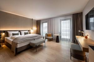 a hotel room with a bed and a desk at ATLANTIC Hotel Heidelberg in Heidelberg