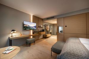 a hotel room with a bed and a table and a tv at ATLANTIC Hotel Heidelberg in Heidelberg +65 photos