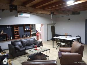 a living room with leather furniture and a table at La Boca in Godoy Cruz