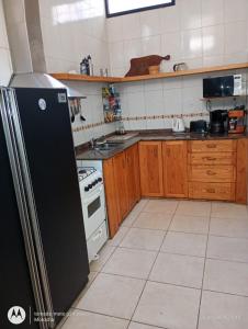 a kitchen with a black refrigerator and a stove at La Boca in Godoy Cruz +5 photos