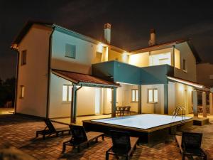 a swimming pool in the courtyard of a house at night at Villa Pikula App1 in Štinjan