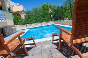 ein Paar Stühle und ein Pool in der Unterkunft Studio für 2 Personen  1 Kind ca 40 qm in Šilo, Kvarner Bucht Krk in Šilo