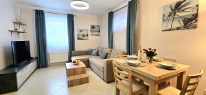 a living room with a table and a couch at Apartament PrzyLesie Jantar by TriApart in Jantar