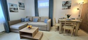 a living room with a couch and a table at Apartament PrzyLesie Jantar by TriApart in Jantar