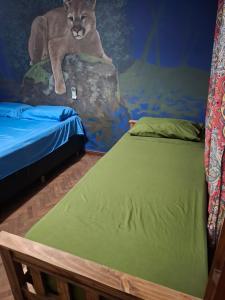 a bedroom with two beds and a mural of a lion at Elisa Posada Hotel in Córdoba