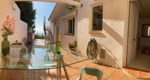 a glass table and chairs on a patio at Villa Panorama Mijas Pueblo in Mijas