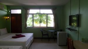 Zimmer mit 2 Betten, einem Tisch und einem Fenster in der Unterkunft Usabuy in Trang