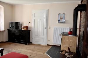 Sala de estar con puerta y TV en Ferienhaus Schäwisch, en Dreis-Brück