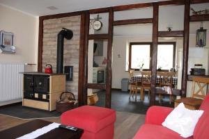 Una sala de estar con un sofá rojo y una mesa. en Ferienhaus Schäwisch, en Dreis-Brück