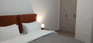 a bed with white sheets and a wooden headboard in a room at Effie's House in Skepastón
