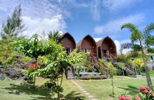 ein tropisches Haus mit einem Garten und Bäumen in der Unterkunft Volcano Retreat in Kubupenlokan