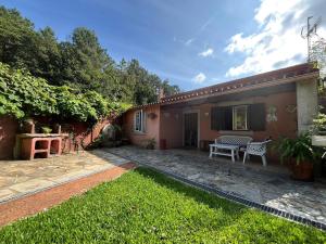 einen Hinterhof eines Hauses mit einem Tisch und einer Bank in der Unterkunft Ferienhaus für 3 Personen  1 Kind ca 70 qm in Brin, Galicien Binnenland von Galicien in Brion