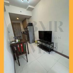 a living room with a large sign on the wall at Staycation BMR Mnl at Coast Residences in Manila