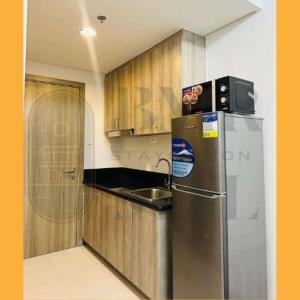 a kitchen with a stainless steel refrigerator and a sink at Staycation BMR Mnl at Coast Residences in Manila