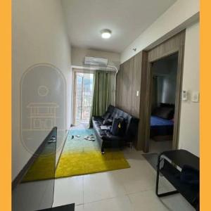 a living room with a couch and a bed at Staycation BMR Mnl at Coast Residences in Manila