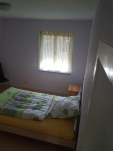 a small bedroom with a bed and a window at Handwerkerhaus Balaro in Weil im Schönbuch