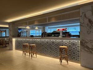 a bar with three bar stools in a restaurant at Hotel Don Juan Tossa in Tossa de Mar