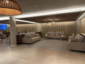 a lobby with couches and a waiting room with a tv at Hotel Don Juan Tossa in Tossa de Mar