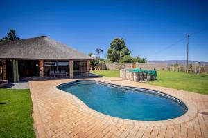 a swimming pool in a yard with a gazebo at Tarantula Guest House in Calvinia