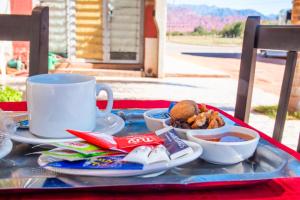 a table with a plate of food and a coffee cup at Posada Los Angeles de Talampaya in Villa Unión