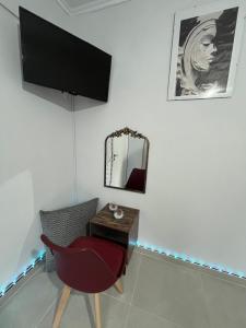 a room with a chair and a table with a mirror at Relatives Apartment in Mytilene