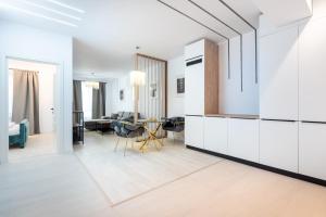 a kitchen with white cabinets and a dining room at ViaPipera Apartments - Modern Stay on Pipera Blvd in Bucharest