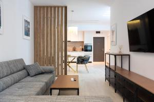 a living room with a couch and a tv and a kitchen at ViaPipera Apartments - Modern Stay on Pipera Blvd in Bucharest