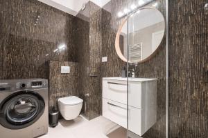 a bathroom with a washing machine and a mirror at ViaPipera Apartments - Modern Stay on Pipera Blvd in Bucharest +27 photos