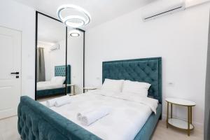 a bedroom with a large bed and a mirror at ViaPipera Apartments - Modern Stay on Pipera Blvd in Bucharest