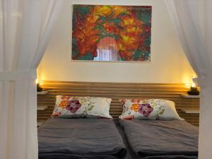 a bedroom with two beds and a painting on the wall at Quinta Perpetua, Casa Flores in Santa Cruz da Graciosa +22 photos