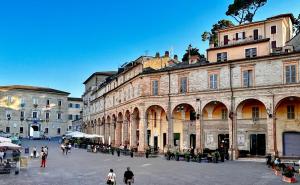 a group of people walking in a plaza in front of buildings at Agriturismo Angeli Sognanti in Cossignano