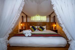 a bedroom with a large bed with two stuffed animals on it at Hotel Boutique Andina de Sal in Uyuni
