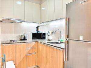 a kitchen with white cabinets and a refrigerator at Family-Friendly Condo Unit in Lapu Lapu City