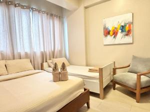 a hotel room with two beds and a chair at Family-Friendly Condo Unit in Lapu Lapu City +20 photos