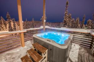 un jacuzzi en una terraza en la nieve en Pärjä Suites 4, en Syöte