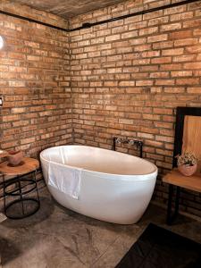 eine große weiße Badewanne in einer Ziegelwand in der Unterkunft Monte Sião Château in Urubici