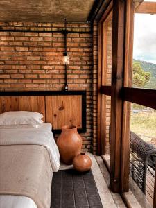 ein Schlafzimmer mit einem Bett und einer Vase neben einem Fenster in der Unterkunft Monte Sião Château in Urubici