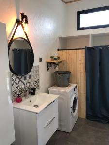 a bathroom with a washing machine and a mirror at L'Accugliente in Lecci